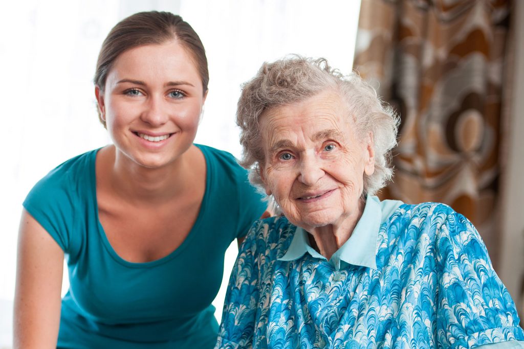 A woman and an old lady smiling for the camera.